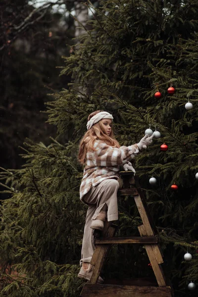 アクティブな少女は 子供の頃にボールを飾るXmasツリーを楽しんで森で休んでいます クリスマスと新年の冬の休暇シーズンの屋外を祝う女性の子供 — ストック写真