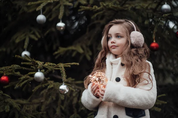 活泼的小女孩在森林里休息 享受着童年装饰球的圣诞树 在户外庆祝圣诞节和新年及寒假的女童 — 图库照片