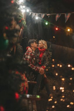 Noel 'i ve yeni yılı kutlayan mutlu çift, kış tatili sezonunu Camper Park' ta kutluyor. Genç çift dinleniyor ve rahatlıyor. Birlikte zaman geçiriyorlar. Xmas karavanı yakınında sarılıp öpüşüyorlar.
