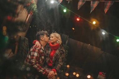 Noel 'i ve yeni yılı kutlayan mutlu çift, kış tatili sezonunu Camper Park' ta kutluyor. Genç çift dinleniyor ve rahatlıyor. Birlikte zaman geçiriyorlar. Xmas karavanı yakınında sarılıp öpüşüyorlar.