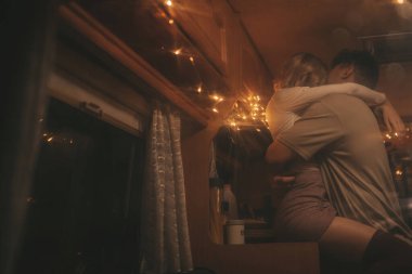 Noel 'i ve yeni yılı kutlayan mutlu çift, kış tatili sezonunu Camper Park' ta kutluyor. Genç çift birlikte zaman geçirir. Xmas karavanının vitrininde sarılır ve öpüşürler.