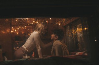 Noel 'i ve yeni yılı kutlayan mutlu çift, kış tatili sezonunu Camper Park' ta kutluyor. Genç çift birlikte zaman geçirir. Xmas karavanının vitrininde sarılır ve öpüşürler.