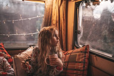 Küçük kız Noel 'i ve yeni yılı kutlarken süt içer ve Noel Baba' yı Noel kampı karavanında bekler.