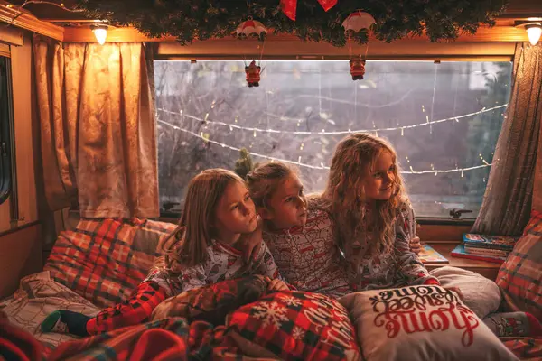 キャンパーでサンタを待っているクリスマスと新年の冬の休暇シーズンを祝う子供たち 子供たちは一緒にグリムを過ごし ミルクを飲み Xmasキャンピングカーのトレーラーでキャンディーケンとクッキーを楽しんでいます — ストック写真