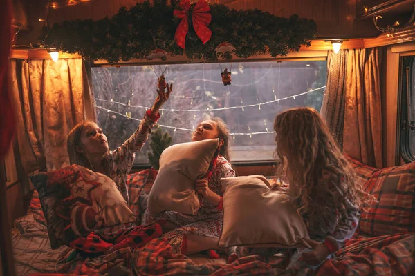 キャンパーでクリスマスと新年の冬の休暇シーズンを祝う女性の子供たち アクティブな子供たちは子供の頃を楽しんでいるXmasキャンパーのトレーラーで楽しい枕の戦いを一緒に過ごす楽しい時間を過ごします — ストック写真