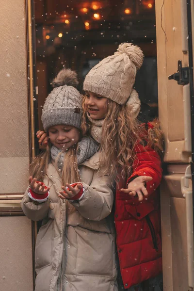 クリスマスと新年の冬の休暇シーズンを祝う子供たちは サンタを待っています Xmasキャンピングカーのトレーラーの近くで一緒に時間を過ごす子供たちは 子供の頃を楽しんでいる最初の雪に喜んでいます — ストック写真