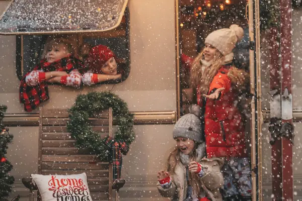 クリスマスと新年の冬の休暇シーズンを祝う子供たちは サンタを待っています Xmasキャンピングカーのトレーラーの近くで一緒に時間を過ごす子供たちは 子供の頃を楽しんでいる最初の雪に喜んでいます — ストック写真