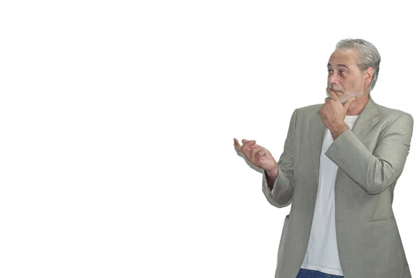Sakallı olgun bir adam sağda beyaz bir arka planda bir şeye bakıyor.