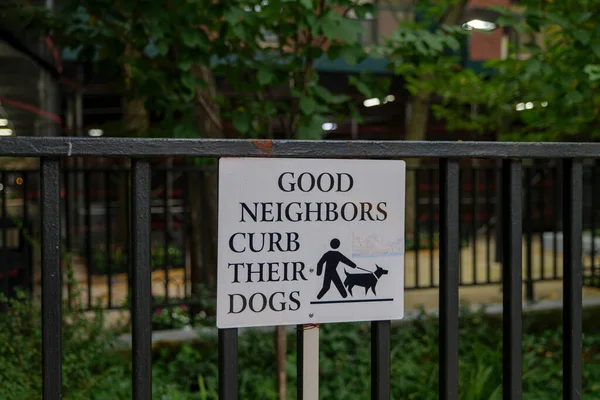 sidewalk urban street sign Good Neighbors Curb Their Dogs. High-quality photo