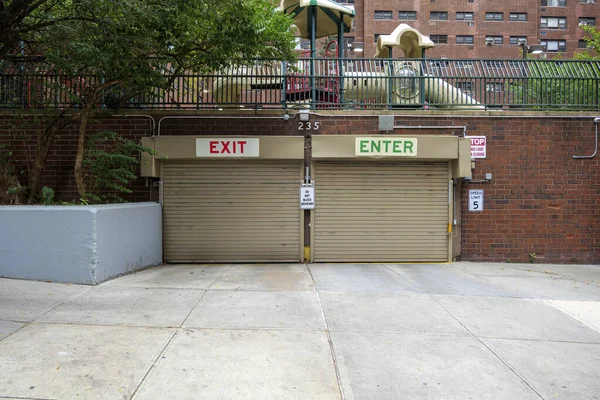 Entrance to the underground garage. Gate to the garage in the building. The office building is brown. High-quality photo