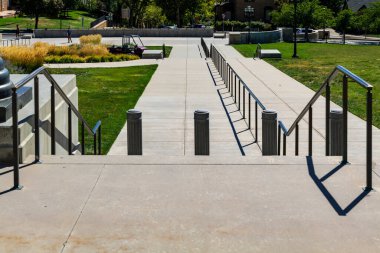 Mermer merdivenlerdeki metal korkuluklar parktaki çim tarlasının önünde. Yüksek kaliteli fotoğraf.