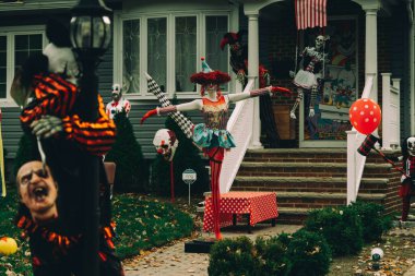  Birçok parlak ve renkli cadılar bayramı süslemeleri, iskeletler, oyulmuş balkabakları, ve bir evin bahçesinde ve ön bahçesinde korkuluklar. Yüksek kaliteli fotoğraf.