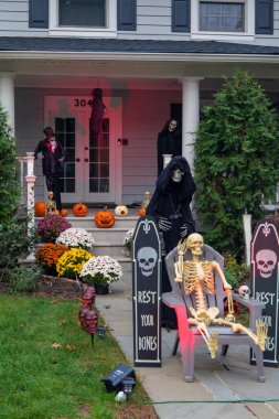  Birçok parlak ve renkli cadılar bayramı süslemeleri, iskeletler, oyulmuş balkabakları, ve bir evin bahçesinde ve ön bahçesinde korkuluklar. Yüksek kaliteli fotoğraf.