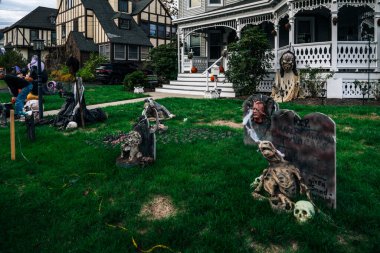  Birçok parlak ve renkli cadılar bayramı süslemeleri, iskeletler, oyulmuş balkabakları, ve bir evin bahçesinde ve ön bahçesinde korkuluklar. Yüksek kaliteli fotoğraf.