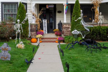  Birçok parlak ve renkli cadılar bayramı süslemeleri, iskeletler, oyulmuş balkabakları, ve bir evin bahçesinde ve ön bahçesinde korkuluklar. Yüksek kaliteli fotoğraf.