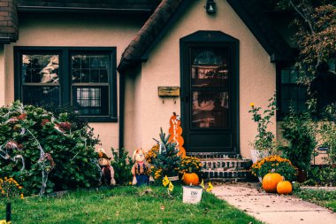  Birçok parlak ve renkli cadılar bayramı süslemeleri, iskeletler, oyulmuş balkabakları, ve bir evin bahçesinde ve ön bahçesinde korkuluklar. Yüksek kaliteli fotoğraf.