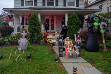  Birçok parlak ve renkli cadılar bayramı süslemeleri, iskeletler, oyulmuş balkabakları, ve bir evin bahçesinde ve ön bahçesinde korkuluklar. Yüksek kaliteli fotoğraf.