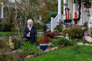  Birçok parlak ve renkli cadılar bayramı süslemeleri, iskeletler, oyulmuş balkabakları, ve bir evin bahçesinde ve ön bahçesinde korkuluklar. Yüksek kaliteli fotoğraf.