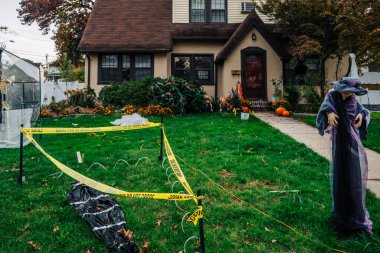  Birçok parlak ve renkli cadılar bayramı süslemeleri, iskeletler, oyulmuş balkabakları, ve bir evin bahçesinde ve ön bahçesinde korkuluklar. Yüksek kaliteli fotoğraf.