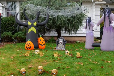  Birçok parlak ve renkli cadılar bayramı süslemeleri, iskeletler, oyulmuş balkabakları, ve bir evin bahçesinde ve ön bahçesinde korkuluklar. Yüksek kaliteli fotoğraf.