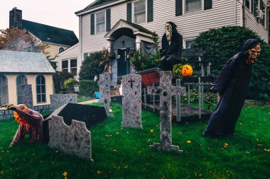  Birçok parlak ve renkli cadılar bayramı süslemeleri, iskeletler, oyulmuş balkabakları, ve bir evin bahçesinde ve ön bahçesinde korkuluklar. Yüksek kaliteli fotoğraf.