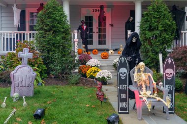  Birçok parlak ve renkli cadılar bayramı süslemeleri, iskeletler, oyulmuş balkabakları, ve bir evin bahçesinde ve ön bahçesinde korkuluklar. Yüksek kaliteli fotoğraf.