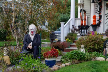  Birçok parlak ve renkli cadılar bayramı süslemeleri, iskeletler, oyulmuş balkabakları, ve bir evin bahçesinde ve ön bahçesinde korkuluklar. Yüksek kaliteli fotoğraf.