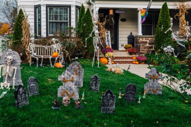  Birçok parlak ve renkli cadılar bayramı süslemeleri, iskeletler, oyulmuş balkabakları, ve bir evin bahçesinde ve ön bahçesinde korkuluklar. Yüksek kaliteli fotoğraf.