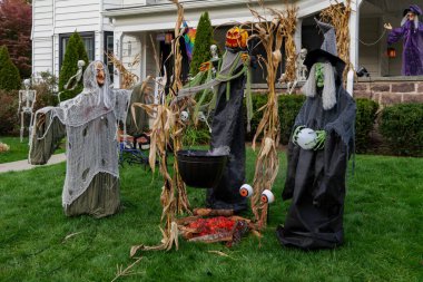  Birçok parlak ve renkli cadılar bayramı süslemeleri, iskeletler, oyulmuş balkabakları, ve bir evin bahçesinde ve ön bahçesinde korkuluklar. Yüksek kaliteli fotoğraf.