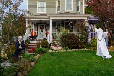  Birçok parlak ve renkli cadılar bayramı süslemeleri, iskeletler, oyulmuş balkabakları, ve bir evin bahçesinde ve ön bahçesinde korkuluklar. Yüksek kaliteli fotoğraf.