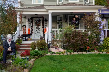  Birçok parlak ve renkli cadılar bayramı süslemeleri, iskeletler, oyulmuş balkabakları, ve bir evin bahçesinde ve ön bahçesinde korkuluklar. Yüksek kaliteli fotoğraf.