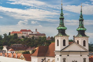 Brno, Çek Cumhuriyeti 13 Eylül 2022: St. Michael Kilisesi önplanda Başmelek Kostel Svateho Michala ve arka planda Spilberk Şatosu güzel sonbahar gününde.