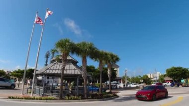 Siesta Key Village, Florida 29 Ekim 2020: Canal Road ve Ocean Blvd kavşağı. Arabalar geçerken bayrak direkleri ve çardağı gösteriyor. 