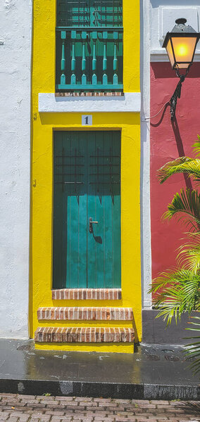 San Juan, Puerto Rico, March 29, 2021- Behind the yellow door is the narrowest house in San Juan Puerto Rico known as La Casa Estrecha or The narrow house. Two stories and once was an alley.