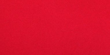 Arka plan olarak kırmızı kadife kumaş dokusu kullanılıyor. Yumuşak ve pürüzsüz tekstil malzemelerinden oluşan boş kırmızı kumaş arka plan. Metin için boşluk var.