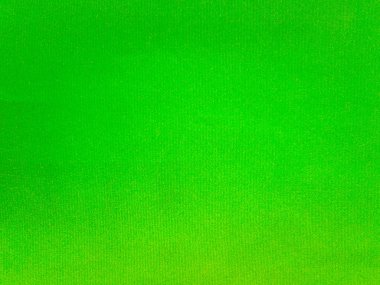 Arka plan olarak kullanılan parlak yeşil kadife kumaş dokusu. Yumuşak ve pürüzsüz tekstil malzemelerinden oluşan boş yeşil kumaş arka planı. Metin için boşluk var.