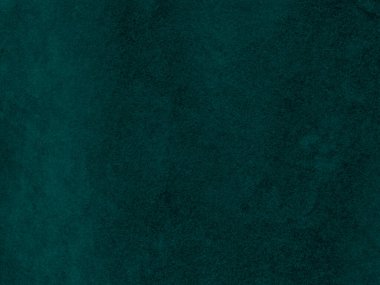 Arka plan olarak kullanılan koyu yeşil kadife kumaş dokusu. Yumuşak ve pürüzsüz tekstil malzemelerinden oluşan boş yeşil kumaş arka planı. Metin için boşluk var.