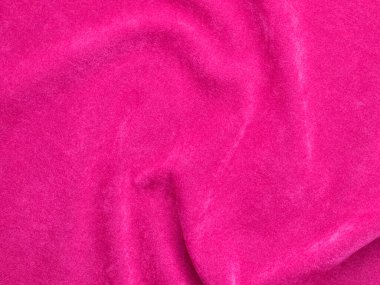 Arka plan olarak kullanılan pembe kadife kumaş dokusu. Yumuşak ve pürüzsüz tekstil malzemelerinin boş pembe kumaş arka planı. Metin için boşluk var.