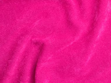 Arka plan olarak kullanılan pembe kadife kumaş dokusu. Yumuşak ve pürüzsüz tekstil malzemelerinin boş pembe kumaş arka planı. Metin için boşluk var.