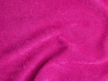 Arka plan olarak kullanılan pembe kadife kumaş dokusu. Yumuşak ve pürüzsüz tekstil malzemelerinin boş pembe kumaş arka planı. Metin için boşluk var.