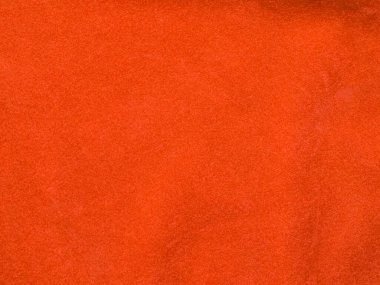 Arka plan olarak turuncu kadife kumaş dokusu kullanılır. Yumuşak ve pürüzsüz tekstil malzemelerinden oluşan boş turuncu kumaş arka plan. Metin için boşluk var.