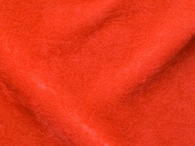 Arka plan olarak turuncu kadife kumaş dokusu kullanılır. Yumuşak ve pürüzsüz tekstil malzemelerinden oluşan boş turuncu kumaş arka plan. Metin için boşluk var.