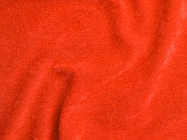 Arka plan olarak turuncu kadife kumaş dokusu kullanılır. Yumuşak ve pürüzsüz tekstil malzemelerinden oluşan boş turuncu kumaş arka plan. Metin için boşluk var.