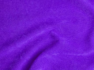 Arka plan olarak kullanılan mor kadife kumaş dokusu. Yumuşak ve pürüzsüz tekstil malzemelerinin boş mor kumaş arkaplanı. Metin için boşluk var.