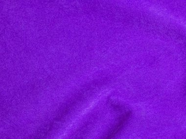Arka plan olarak kullanılan mor kadife kumaş dokusu. Yumuşak ve pürüzsüz tekstil malzemelerinin boş mor kumaş arkaplanı. Metin için boşluk var.