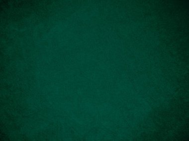Arka plan olarak kullanılan koyu yeşil kadife kumaş dokusu. Yumuşak ve pürüzsüz tekstil malzemesinin ton rengi yeşil kumaş arka planı. Metin ve tüm tasarım işleri için yer var
