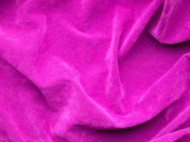 Arka plan olarak kullanılan pembe kadife kumaş dokusu. Yumuşak ve pürüzsüz tekstil malzemelerinin boş pembe kumaş arka planı. Metin için boşluk var.