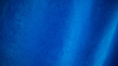 Arka plan olarak mavi kadife kumaş dokusu kullanılıyor. Yumuşak ve pürüzsüz tekstil malzemelerinin boş mavi kumaş arka planı. Metin için boşluk var.