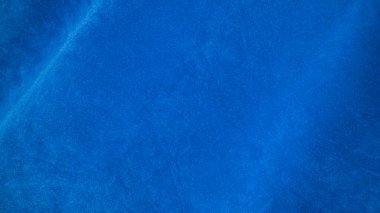 Arka plan olarak mavi kadife kumaş dokusu kullanılıyor. Yumuşak ve pürüzsüz tekstil malzemelerinin boş mavi kumaş arka planı. Metin için boşluk var.