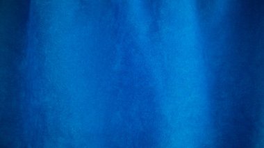 Arka plan olarak mavi kadife kumaş dokusu kullanılıyor. Yumuşak ve pürüzsüz tekstil malzemelerinin boş mavi kumaş arka planı. Metin için boşluk var.